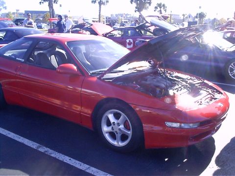 1995 Ford Probe - Red 1995 Ford Probe on display with its hood open, parked in a lot with other vehicles.