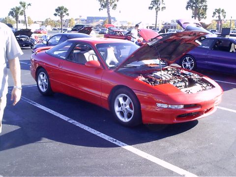 1995 Ford Probe - A red 1995 Ford Probe is displayed with its hood open at an outdoor car event.