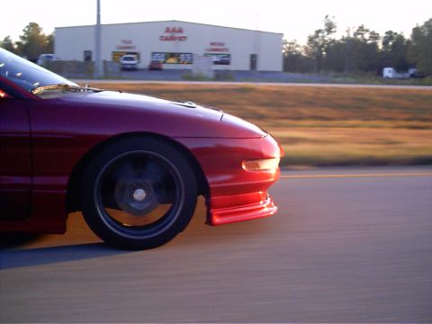1995 Ford Probe - Front quarter view of a red 1995 Ford Probe in motion on a highway.