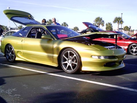 1995 Ford Probe - Lime green 1995 Ford Probe on display with its hood and trunk open, parked outdoors.