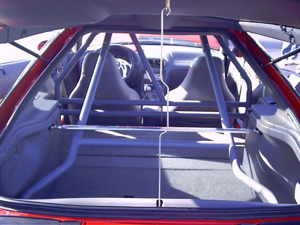 Interior view of a 1995 Ford Probe with a roll cage installed, showing the front seats and dashboard