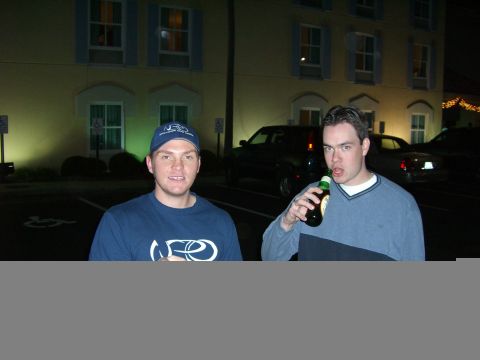 1996 Ford Probe - Two men are standing in front of a building at night, with cars parked behind them.