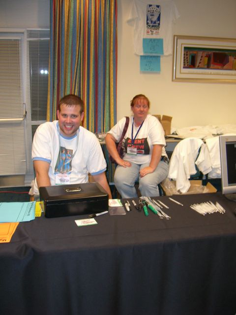 1996 Ford Probe - Two people are seated behind a table covered with a black cloth, with various items laid out.
