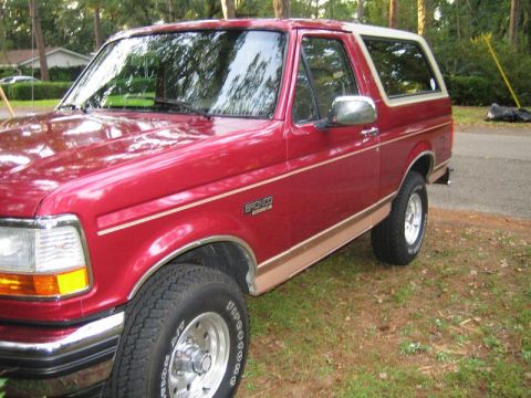 1994 Ford Bronco - This red 1994 Ford Bronco features a tan accent stripe and a white removable hardtop.