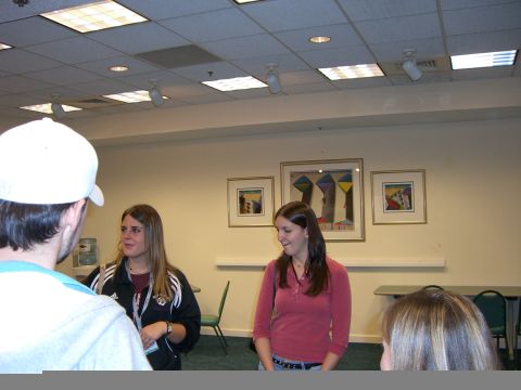 1996 Ford Probe - A group of people are standing in a room with framed artwork on the wall.