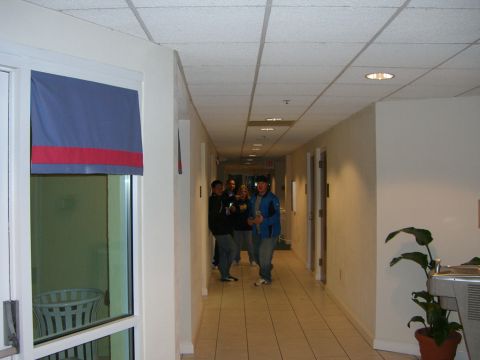 1996 Ford Probe - People walk down a long interior hallway with tiled floors and office doors.