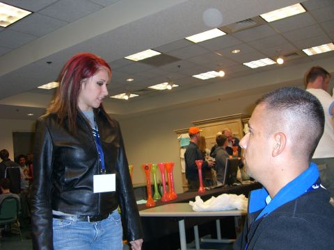 1996 Ford Probe - Attendees converse near a table displaying colorful cups at an indoor event.