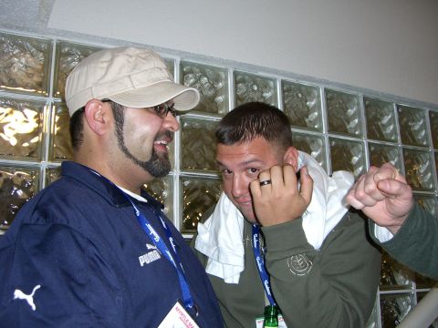 1996 Ford Probe - Two men converse in front of a glass block wall, one wearing a Puma jacket and the other a green hoodie.