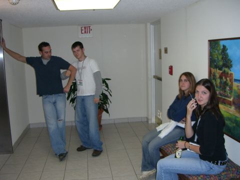 1996 Ford Probe - Four people are in a hallway, two standing and two sitting, with a painting on the wall.