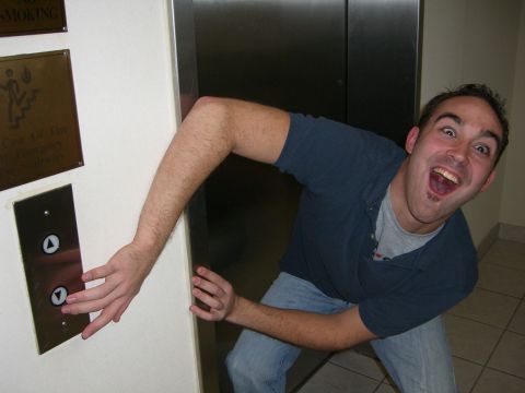 1996 Ford Probe - Man excitedly presses an elevator call button, with a metal elevator door behind him.