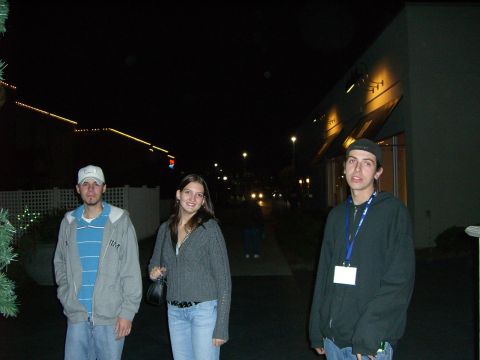 1996 Ford Probe - Three individuals are captured in a nighttime scene outside a lit building.