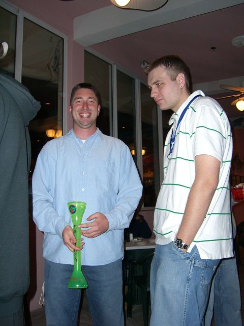 1996 Ford Probe - Two men are standing indoors, one holding a large green novelty drink container.
