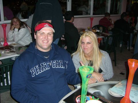 1996 Ford Probe - A man and a woman sit at a table in an outdoor dining area, with other patrons visible in the background.