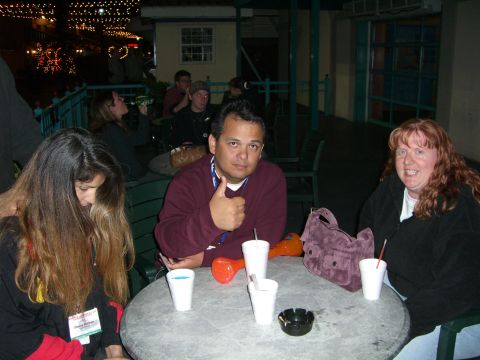 1996 Ford Probe - Several people are gathered around a table, some with drinks, in an outdoor setting at night.