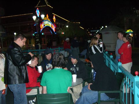 1996 Ford Probe - People socialize at outdoor tables in front of a lit building at night.