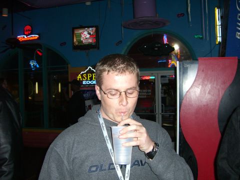 1996 Ford Probe - A man sips a drink in a dimly lit establishment with neon signs and a television in the background.