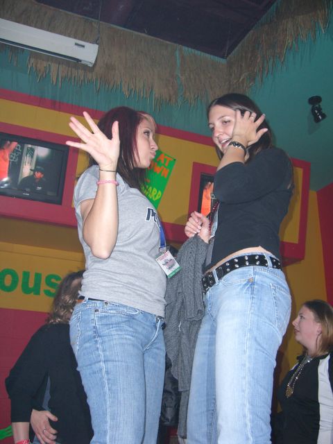 1996 Ford Probe - Two women engage in conversation in a lively indoor setting.