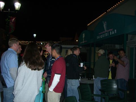 1996 Ford Probe - People socialize outside a daiquiri bar at night, illuminated by string lights and lamps.