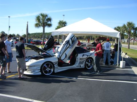 1996 Ford Probe - Customized 1996 Ford Probe on display with doors open, attracting attention at a car show.