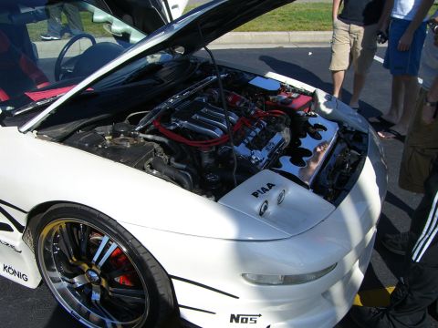 1996 Ford Probe - A white sports car's engine bay is displayed with custom chrome parts and racing decals.