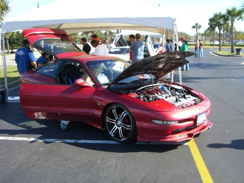 1996 Ford Probe - A red 1996 Ford Probe is displayed with its hood and doors open at an outdoor event.