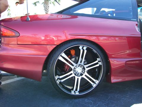 1996 Ford Probe - Close-up of a red car's rear side, showing a custom wheel and brake caliper.