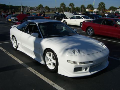 1996 Ford Probe - A white 1996 Ford Probe with an aftermarket body kit is parked at an outdoor car meet.