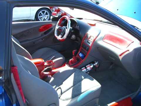 1996 Ford Probe - The interior of a car features extensive red trim and a fire extinguisher mounted near the passenger seat.
