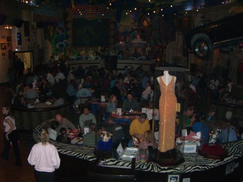 1996 Ford Probe - A restaurant interior scene shows diners, a display dress, and a car suspended overhead.