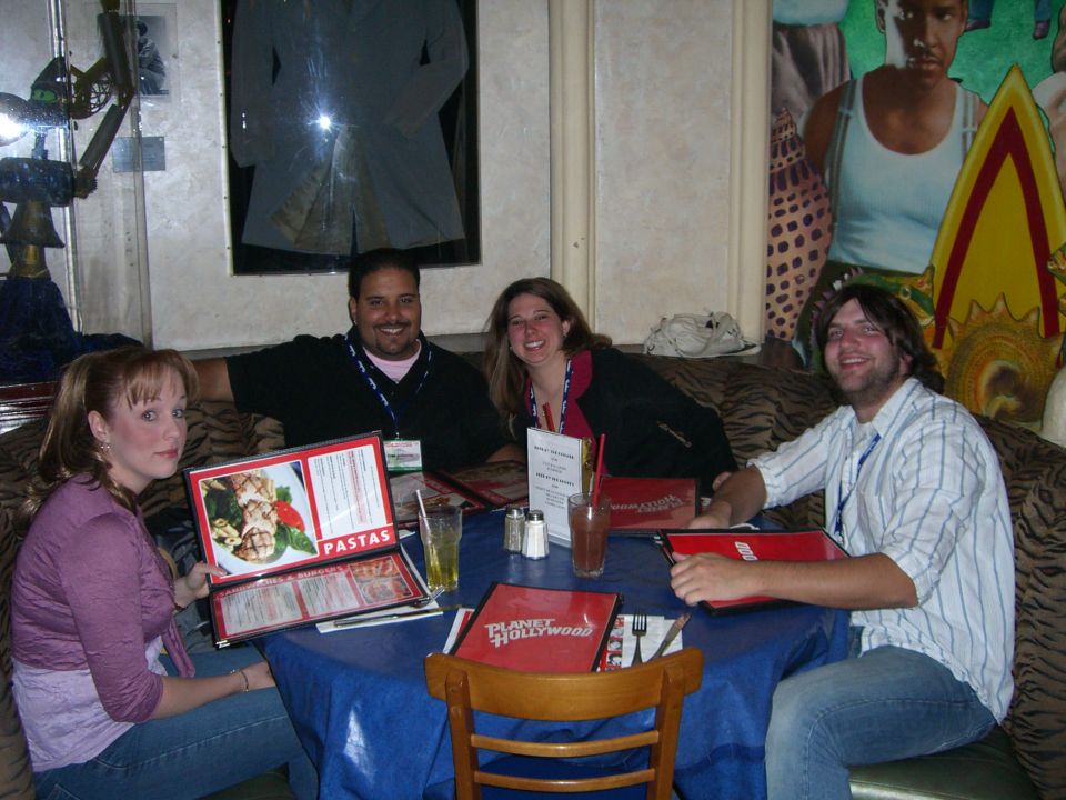 Four people sit around a table at Planet Hollywood, looking at menus