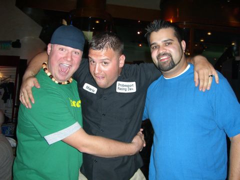1996 Ford Probe - Three friends share a moment, with one man wearing a lei and another sporting a shirt from 'Probesport Racing Dev.'