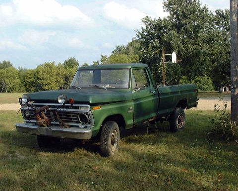 1985 Ford F-150 - This green pickup truck features a winch and is parked outdoors on a grassy area.