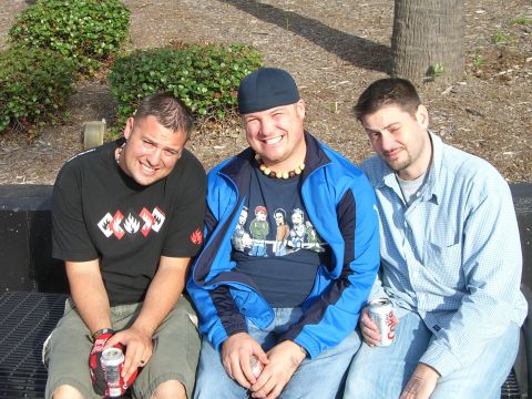 1996 Ford Probe - Three men are seated on a bench, smiling and holding cans of soda on a sunny day.