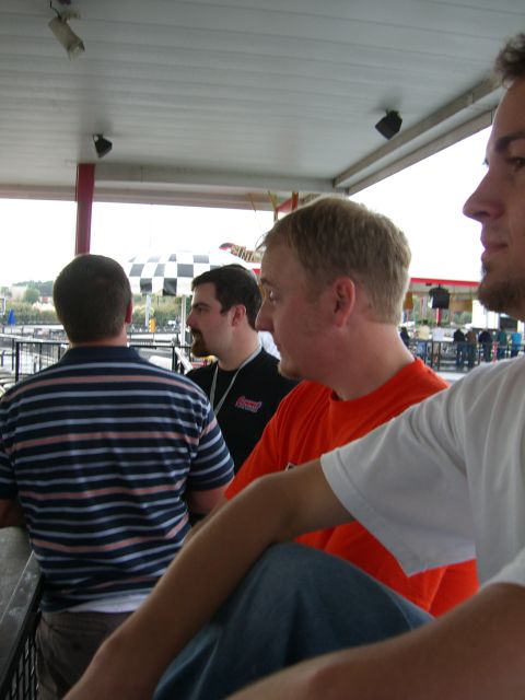 1996 Ford Probe - Several individuals are seen conversing outdoors, with a checkered umbrella visible in the distance.