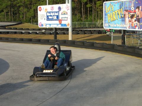 1996 Ford Probe - A person drives a go-kart on a track, with advertisements in the background.