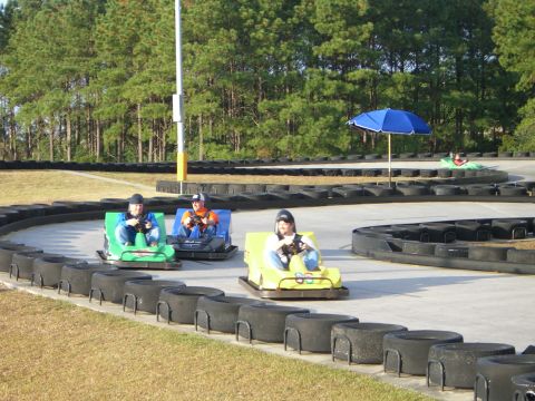 1996 Ford Probe - Go-karts race on a track with drivers enjoying the ride on a sunny day.