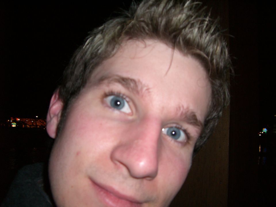 Close-up of a man's face with blue eyes and spiky blond hair