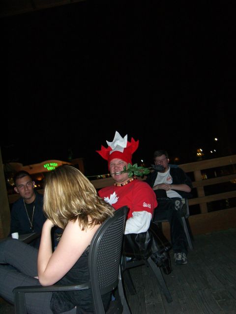 1996 Ford Probe - Several people are gathered at tables, with two individuals chewing on roses and one wearing a Canadian-themed hat.