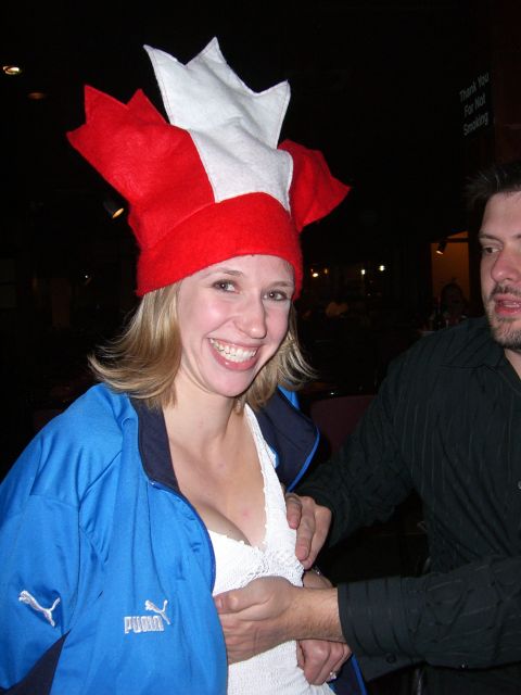 1996 Ford Probe - A woman wearing a festive red and white hat and a blue Puma jacket smiles for the camera, with a man's hand touching her chest.