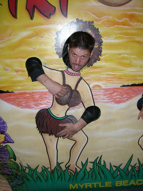 1996 Ford Probe - A man poses in a beach-themed photo booth cutout with a hula dancer design.