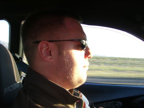 1996 Ford Probe - A man is driving a vehicle, with the word PROBE visible on the headrest of the seat.