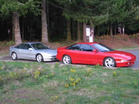 1996 Ford Probe - A silver and a red Ford Probe are parked next to each other on a roadside with trees in the background.