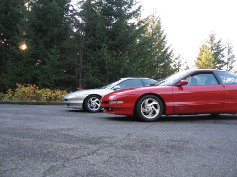 1996 Ford Probe - Two 1996 Ford Probes, one red and one silver, are parked next to each other outdoors.