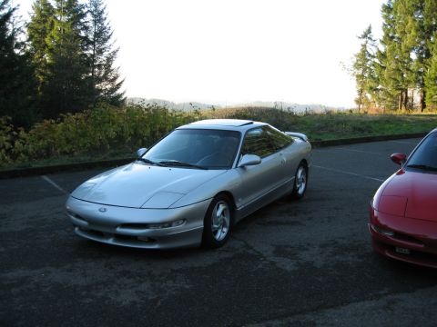 1996 Ford Probe - Two Ford Probes are parked outdoors on a paved surface with trees in the background.