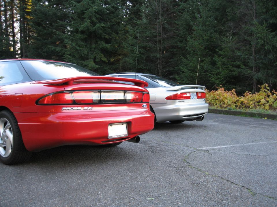 Rear view of a red 1996 Ford Probe and a silver Ford Probe parked side-by-side