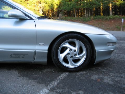 1996 Ford Probe - A silver car with a GT badge is parked on asphalt with trees in the background.