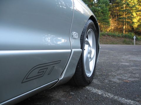 1996 Ford Probe - Close-up of a silver car's side profile, showing a GT badge and a multi-spoke alloy wheel.
