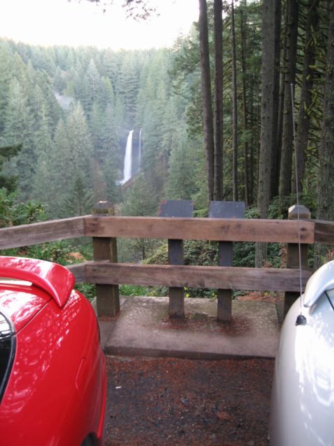 1996 Ford Probe - A scenic view of a waterfall surrounded by a dense forest, with two cars parked nearby.