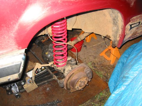 1991 Ford Explorer - The vehicle's rear suspension system is shown with a bright pink coil spring and exposed axle components.