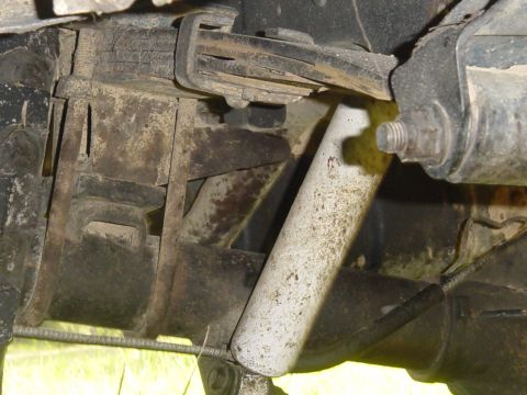 1989 Ford Bronco - Undercarriage view showing the rear suspension system, including leaf springs and a shock absorber.